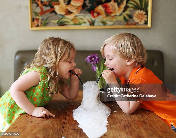 2 children playing with a glass of milk - boy drinking milk stock pictures, royalty-free photos & images