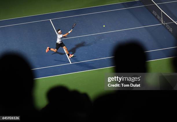 Roger Federer of Switzerland plays a forehand during his match against Benoit Paire of France on day two of the ATP Dubai Duty Free Tennis...