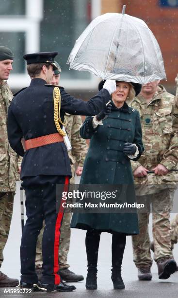 Camilla, Duchess of Cornwall is handed an umbrella by an equerry as she inspects soldiers of 4th Battalion The Rifles during a homecoming parade of...
