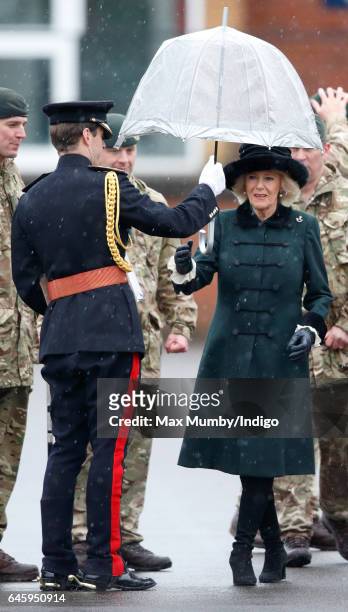 Camilla, Duchess of Cornwall is handed an umbrella by an equerry as she inspects soldiers of 4th Battalion The Rifles during a homecoming parade of...