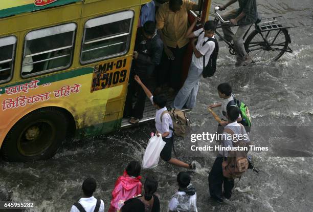 School children wade through the flood at Kurla to board a BEST bus on Friday after heavy rains lashed the city in the morning.