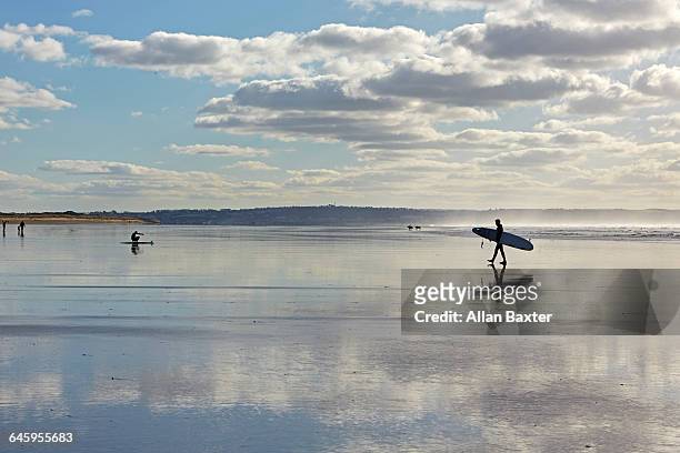 silhouette of surfers across saunton sands - exeter england 個照片及圖片檔