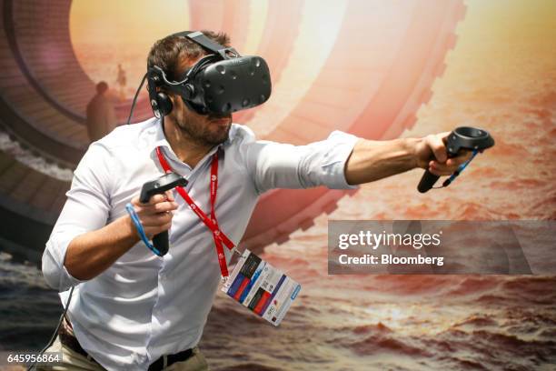 An attendee uses a Vive virtual reality headset, manufactured by HTC Corp., in a boxing match simulation on the opening day of the Mobile World...