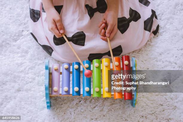 toddler playing a xylophone at home - xylophone stock-fotos und bilder