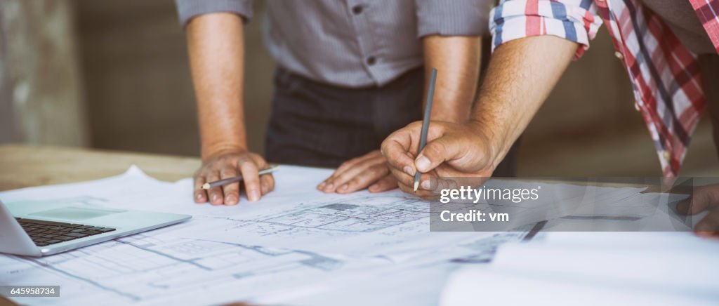 Close up of two people reviewing building blueprints