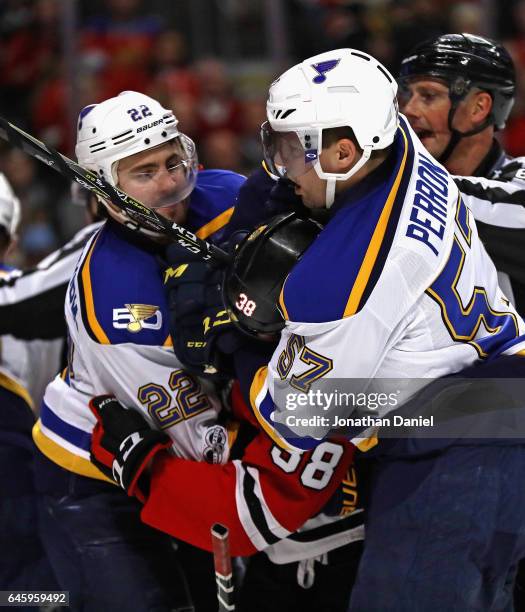 Kevin Shattenkirk and David Perron of the St. Louis Blues hold Ryan Hartman of the Chicago Blackhawks during an altercation in the third period at...