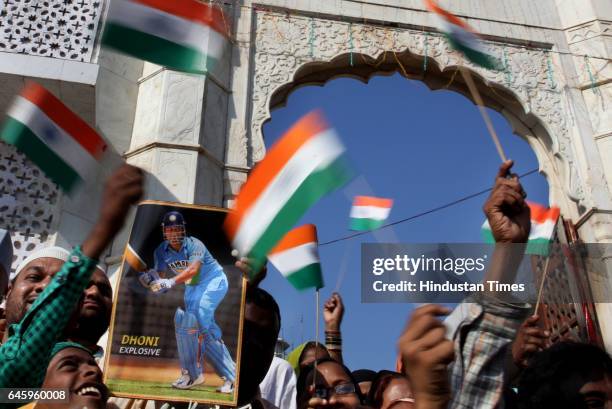 Indian Muslims hold Indian national flags and a picture of Indian cricket team captain Mahendra Singh Dhoni after a special prayer organised to seek...