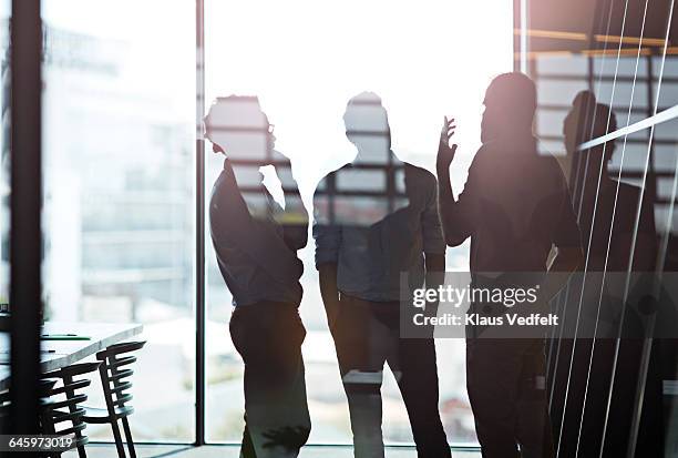 silhuet of businessmen having discussion - back lit window stock pictures, royalty-free photos & images