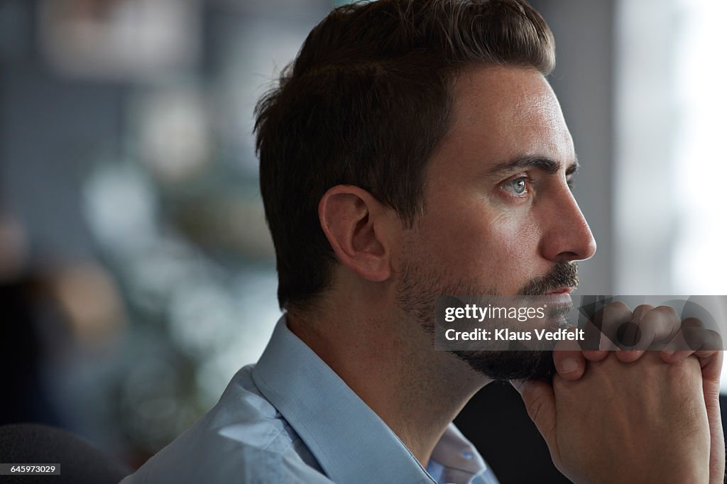 Portrait of businessman looking out of window