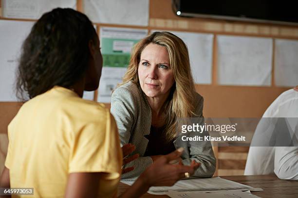 woman listening to co-worker at meeting - listening stock pictures, royalty-free photos & images