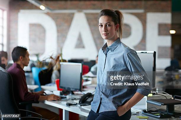 portrait of creative businesswoman at open office - leanincollection stockfoto's en -beelden