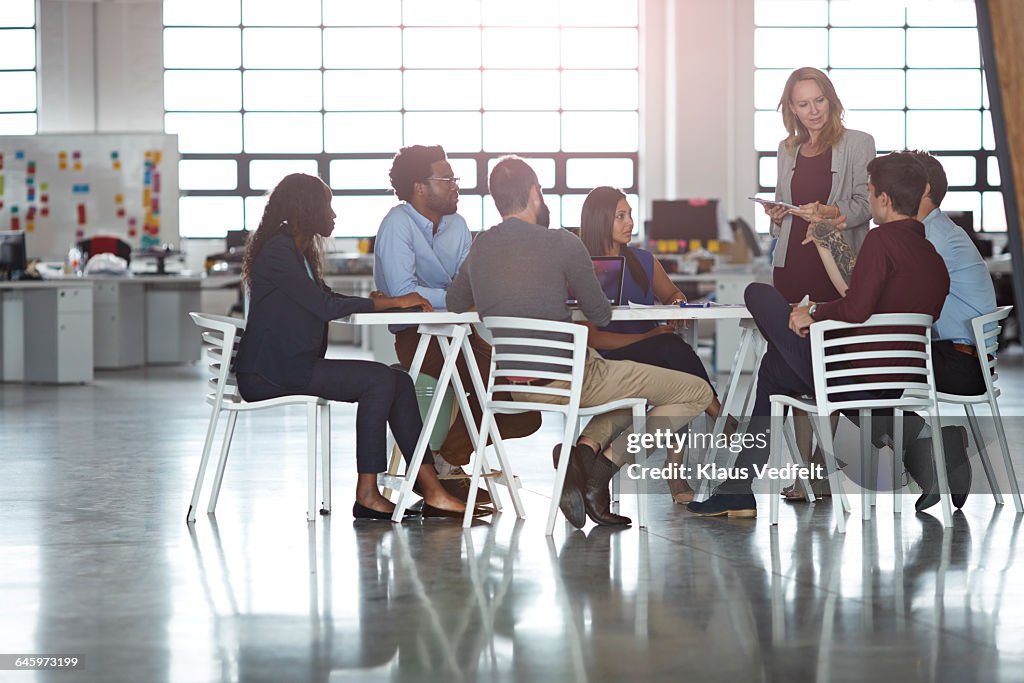 Businesspeople having meeting in big open office