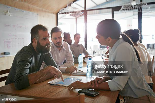 man explaing to co-workers, using tablet - interactive whiteboard foto e immagini stock