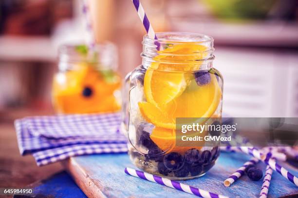 infused water with fresh blueberries and oranges - infused water stock pictures, royalty-free photos & images