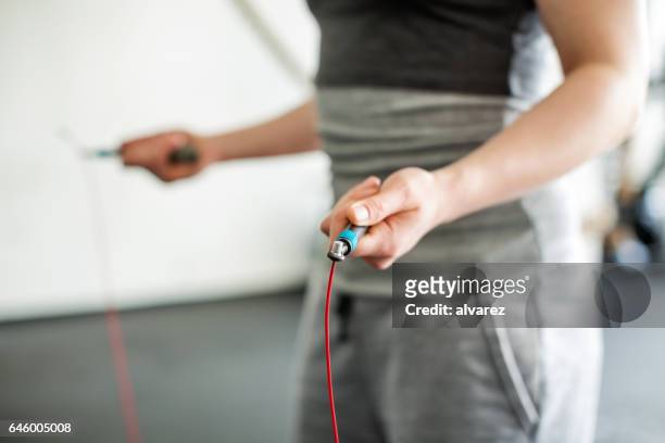 vrouw handen springtouw van het bedrijf in de sportschool - touwtje springen stockfoto's en -beelden