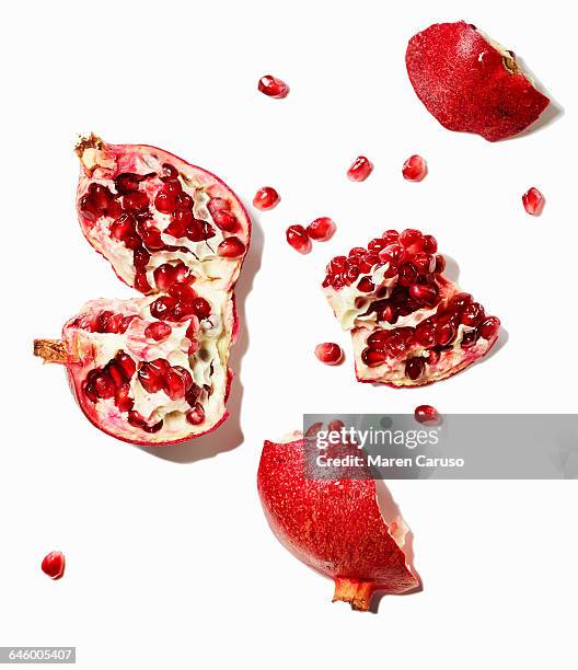 pomegranate and seeds on white background - granaatappel stockfoto's en -beelden