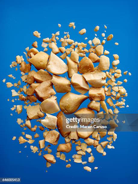 crushed peanuts on blue background - broyé photos et images de collection