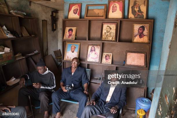 Positive films, which were developed and archived in the past, and the framed old photo prints are seen as people sit at Daouda Coulibaly's photo...