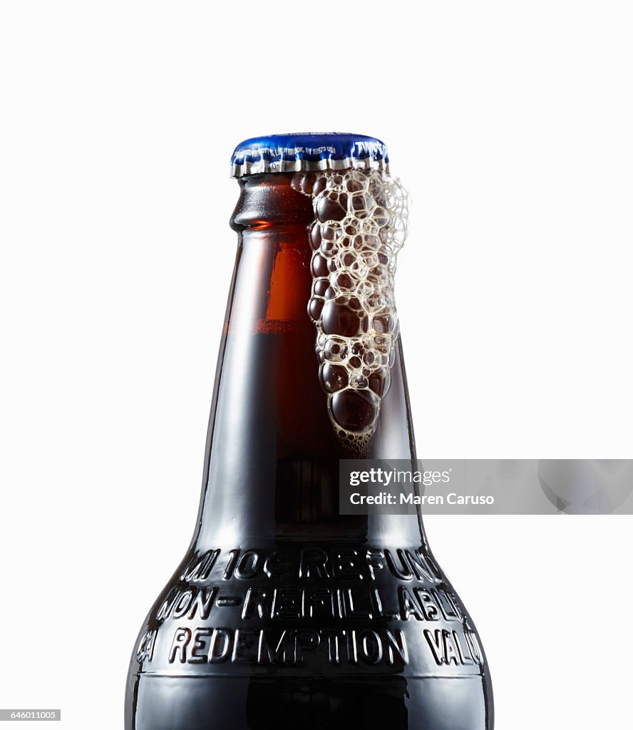 Close up of root beer bottle lid and bubbles