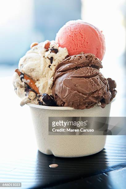 three scoops of ice cream in a paper cup - ice creams photos et images de collection