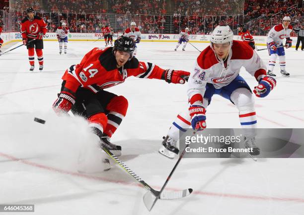 Adam Henrique of the New Jersey Devils and Alexei Emelin of the Montreal Canadiens pursue the puck during the second period at the Prudential Center...