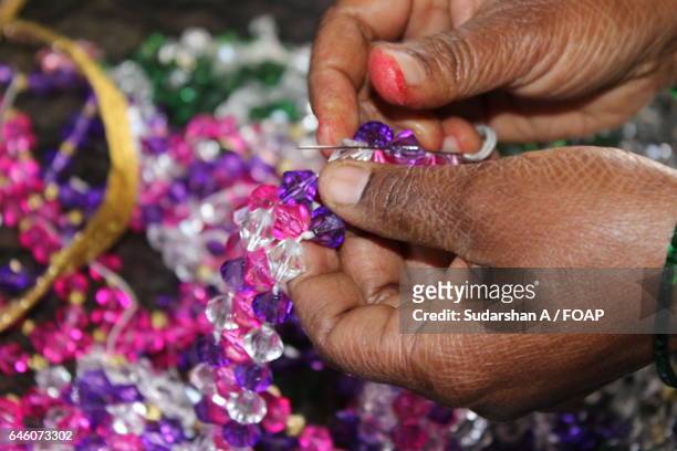 close-up of a woman preparing bracelet - hacer cuentas fotografías e imágenes de stock