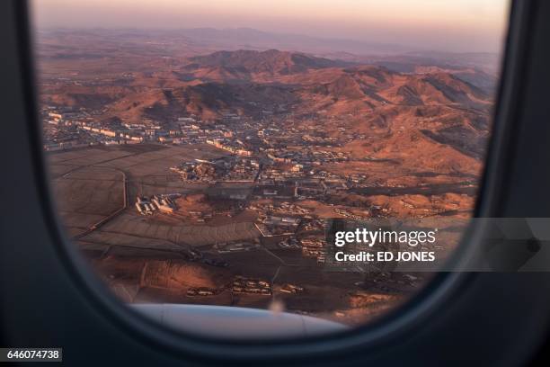 This photo taken on November 24, 2016 shows an aerial view of a town seen from the window of a Tupolev Tu-204 aircraft on approach to Sunan Pyongyang...