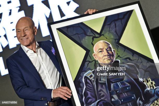 "Professor X" in the X-Men series' Patrick Stewart poses for photos with a gift of a painting during a press conference for the film "Logan" in...