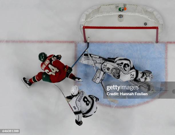 Mikael Granlund of the Minnesota Wild scores the game-winning goal Jonathan Quick and Drew Doughty of the Los Angeles Kings in overtime of the game...