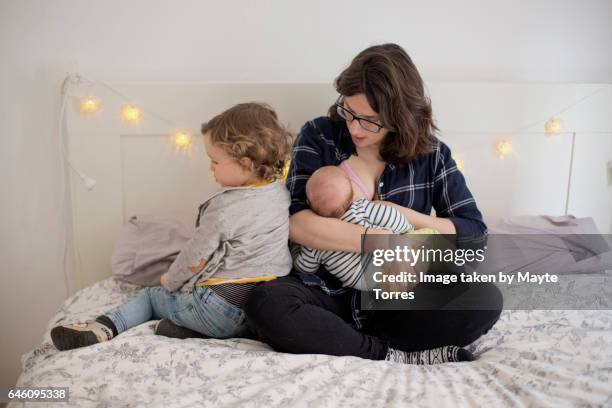 mom breastfeeding baby with toddler - sibling jealousy stock pictures, royalty-free photos & images