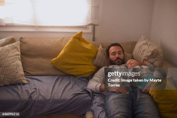 nap on top of dad in the sofa - human fertility stock pictures, royalty-free photos & images