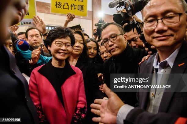 Hong Kong leadership hopeful Carrie Lam is surrounded by pro-democracy protestors and security as she prepares to speak to the media after submitting...