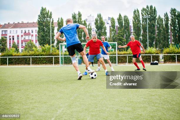 senior football players in action - leisure equipment stock pictures, royalty-free photos & images