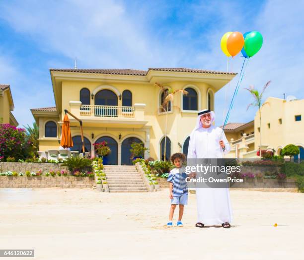 großartiger vater und sohn mit luftballons am strand - arab villa stock-fotos und bilder