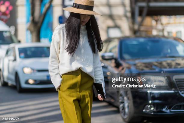 Yoyo Cao wearing mustard wide leg pants, white turtleneck, straw hat outside Armani during Milan Fashion Week Fall/Winter 2017/18 on February 27,...