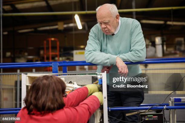 John Elliott, founder of Ebac Ltd., talks with an employee she assembles a washing machine on the production line at the Ebac Ltd. Factory in Newton...