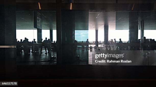 Travellers are seen in front of the exit where one of Kim Jong Nam's attacker are believed to board a taxi after the attack happens in Kuala Lumpur...