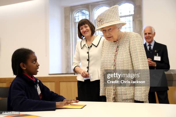 Queen Elizabeth II talks with a local school child as she opens a new development at The Charterhouse at Charterhouse Square on February 28, 2017 in...