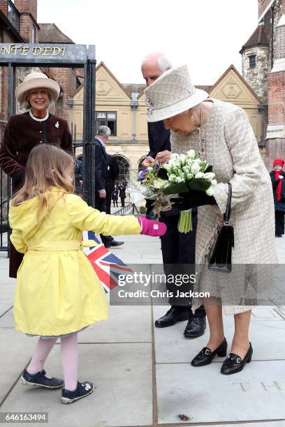 Queen Elizabeth II receives flowers from a child as she and Prince Philip, Duke of Edinburgh open a new development at The Charterhouse at...