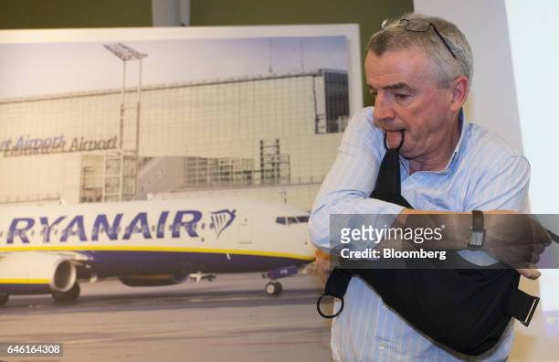Michael O'Leary, chief executive officer of Ryanair Holdings Plc, adjusts his supportive arm sling during a news conference at the Squaire commercial...
