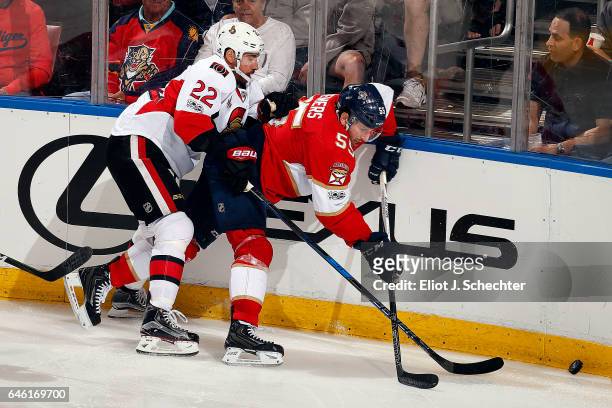Jason Demers of the Florida Panthers digs the puck out from the boards against Chris Kelly of the Ottawa Senators at the BB&T Center on February 26,...