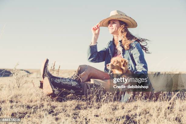 cowgirl sitting outdoors with her dog - chaps stock pictures, royalty-free photos & images