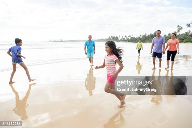young girl and boy playing on beach with family - indian family vacation stock pictures, royalty-free photos & images