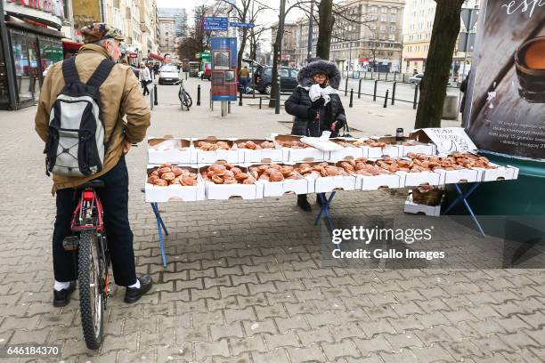 Man buys donuts on the street during Fat Thursday on February, 23 in Warsaw, Poland. Fat Thursday is a traditional Catholic Christian feast...