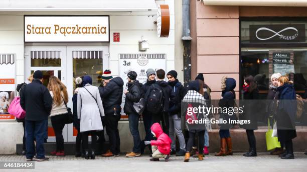 People standing in line in front of a bakery during Fat Thursday on February, 23 in Warsaw, Poland. Fat Thursday is a traditional Catholic Christian...