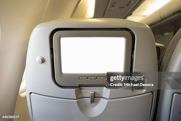 airline video screen on back of seat - vliegtuigstoel stockfoto's en -beelden