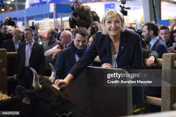 French far-right political Party National Front Leader and Presidential candidate Marine Le Pen poses next to the mascott as she visits Le Salon De...