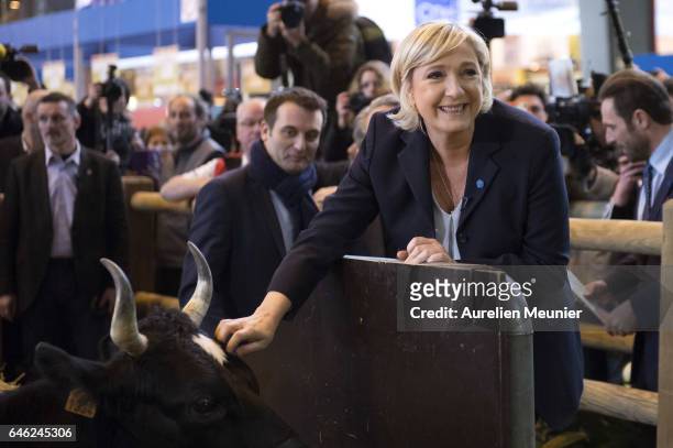 French far-right political Party National Front Leader and Presidential candidate Marine Le Pen poses next to the mascott as she visits Le Salon De...