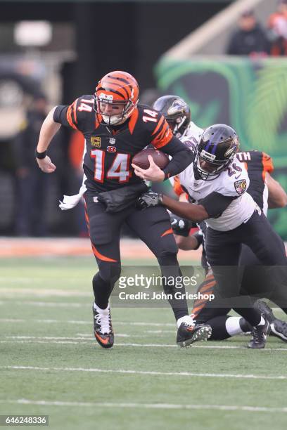 Andy Dalton of the Cincinnati Bengals runs the football upfield against Jerraud Powers of the Baltimore Ravens during their game at Paul Brown...