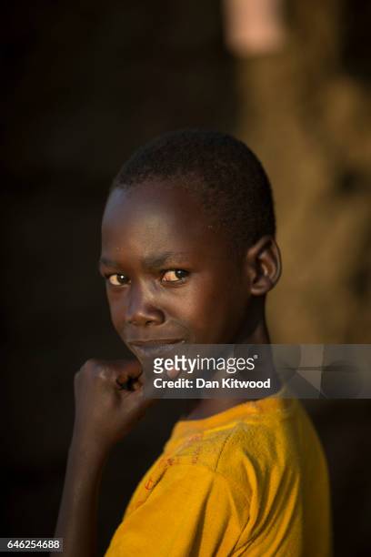 Young boy stands in the doorway of a mud hut at the Kuluba Collection Point after being brought from the South Sudanese border on February 24, 2017...